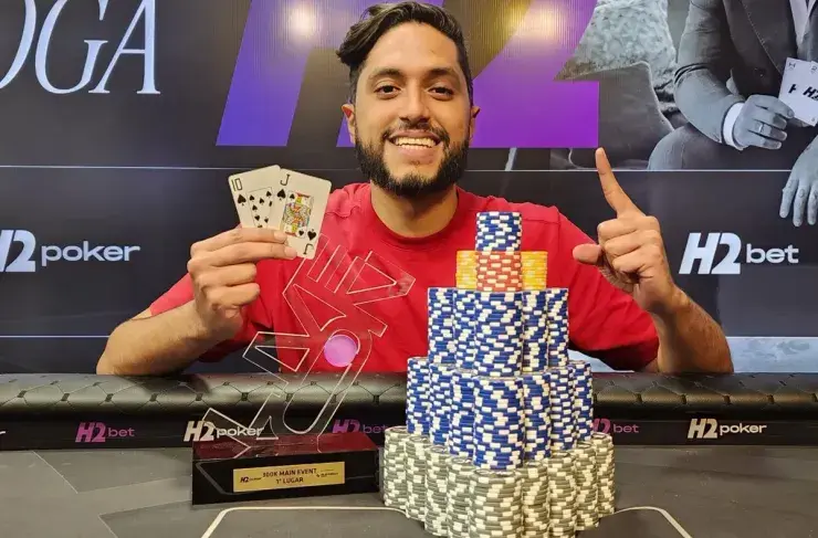 Daniel Aquiles showing winning hand and trophy
